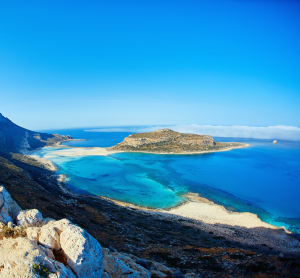 Atemberaubender Blick auf die Lagune von Balos auf Kreta mit türkisblauem Wasser, Sandstränden und felsiger Küstenlandschaft unter klarem Himmel.