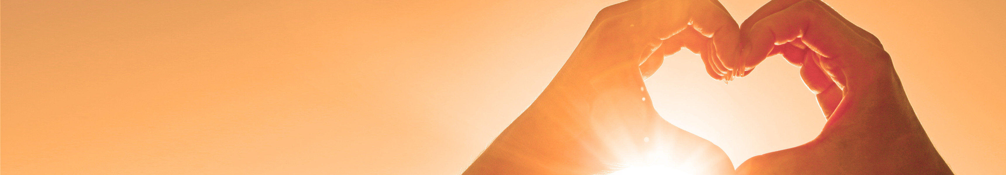 ände formen ein Herz vor der Sonne bei goldenem Abendhimmel