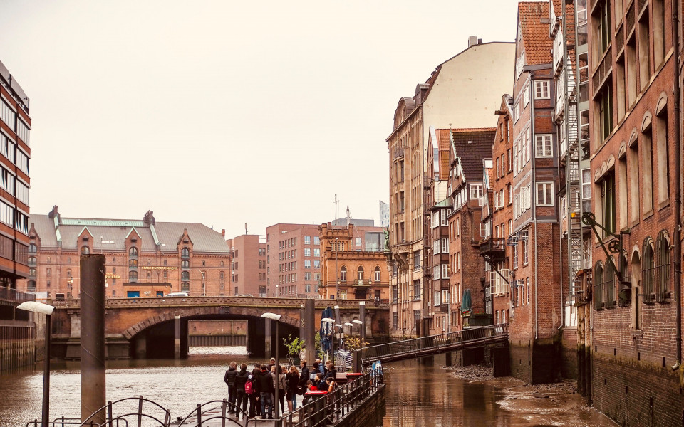 Malerischer Blick auf die historische Deichstraße in Hamburg, mit ihren traditionellen Kaufmannshäusern entlang eines Fleets, im Hintergrund die Speicherstadt mit ihren Backsteinbauten und Brücken.