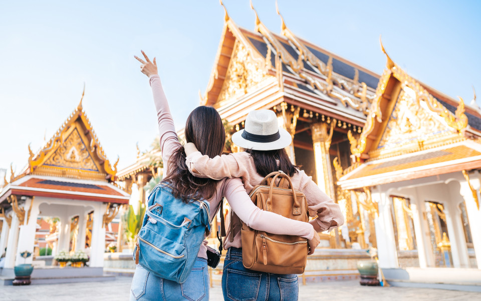 Zwei glückliche Reisende an einem Tempel in Thailand